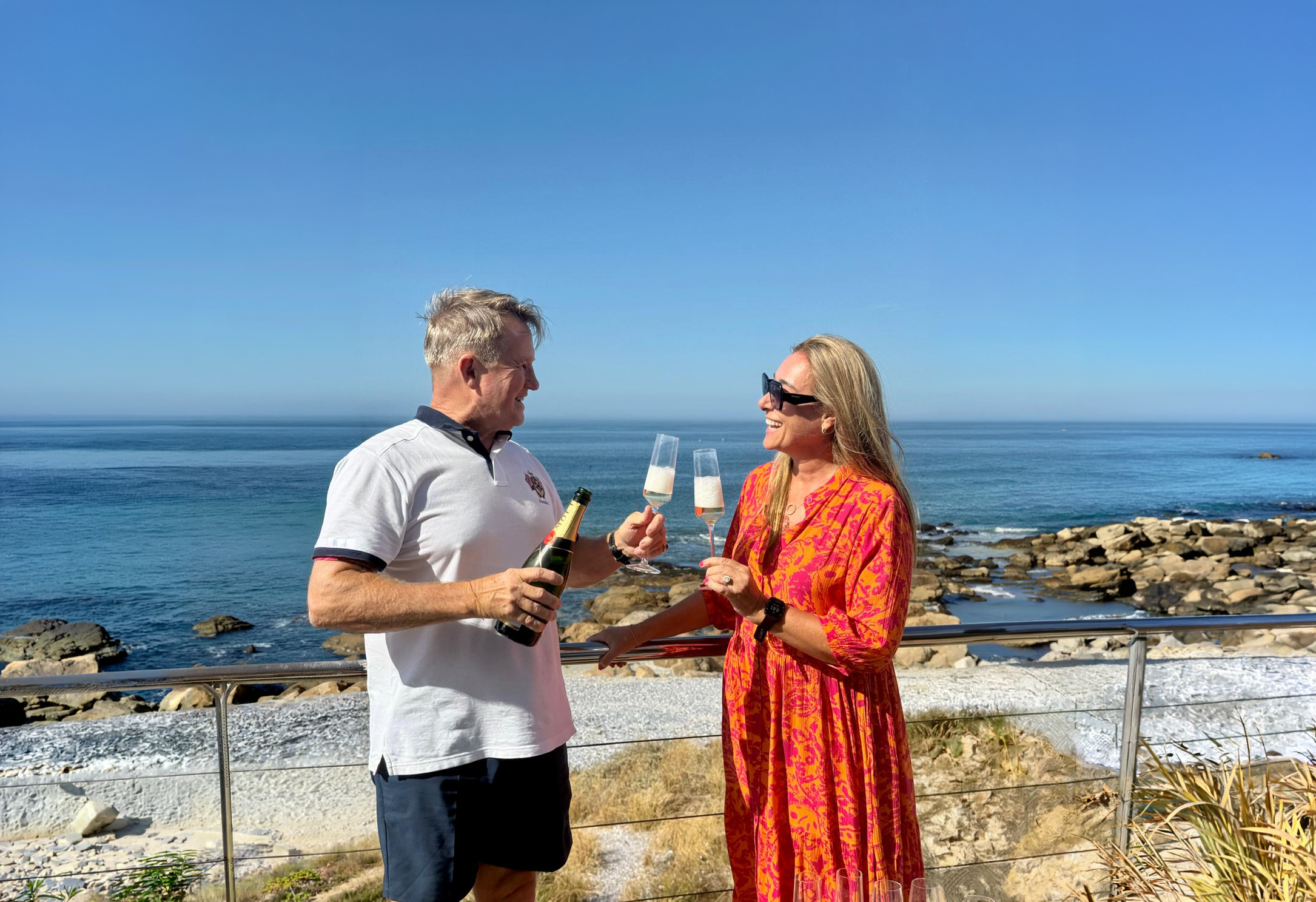 Timothy and Kathrin toasting with champagne above the sea